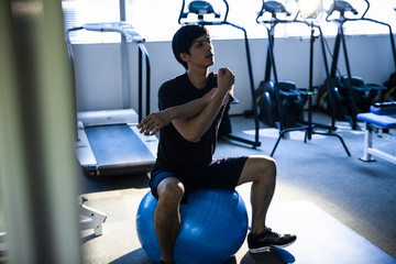 sportif qui fait ses étirements après la séance